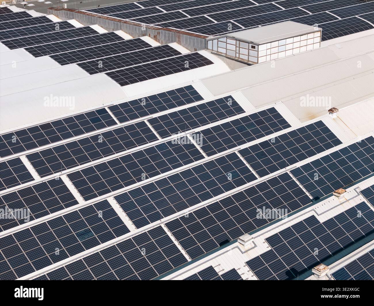 Vista aerea degli edifici industriali con pannelli solari sui tetti, che promuovono l'efficienza energetica e pratiche logistiche sostenibili. Foto Stock