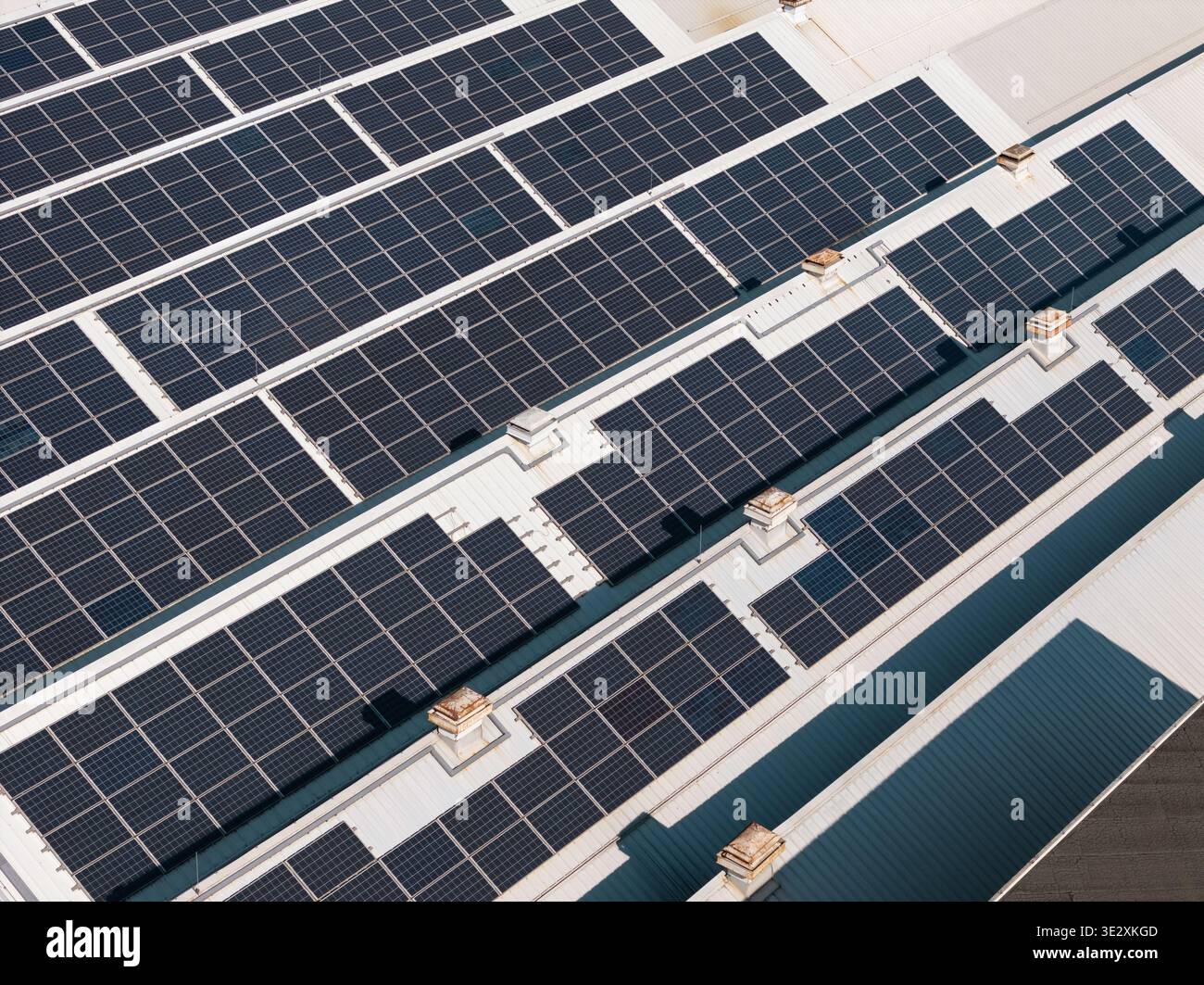 La vista aerea mostra gli edifici industriali coperti da pannelli solari, sottolineando l'uso di energia rinnovabile per l'efficienza e la sostenibilità. Foto Stock