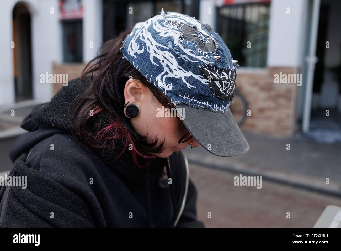 Profilo di un giovane che indossa un berretto stile punk personalizzato e una barella per orecchie Foto Stock