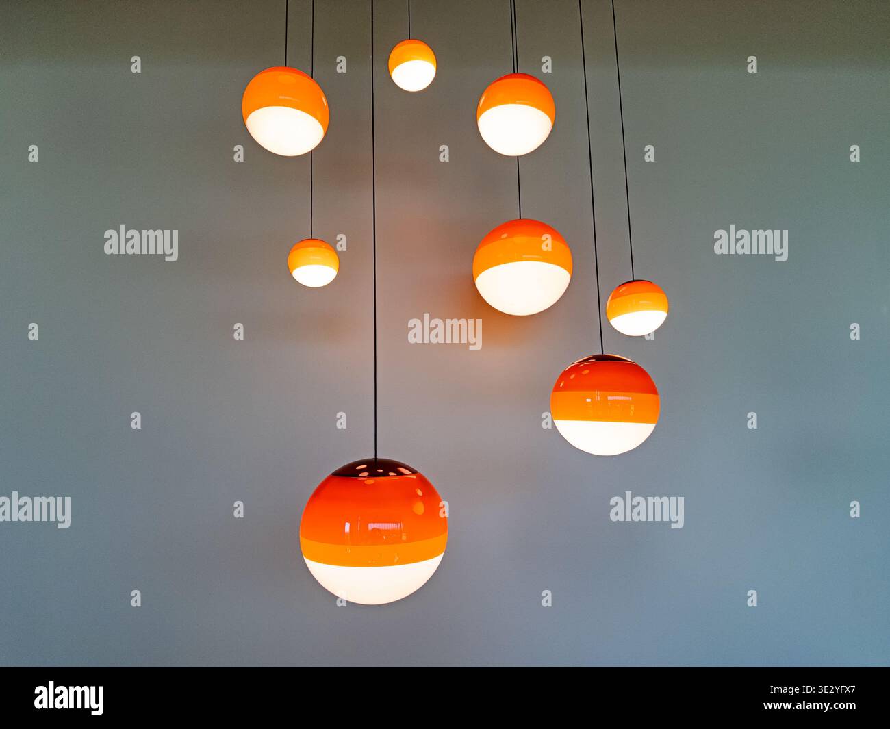 Un semplice apparecchio di illuminazione con globi di vetro che si abbassano dal soffitto assomiglia ai pianeti del sistema solare. Foto Stock