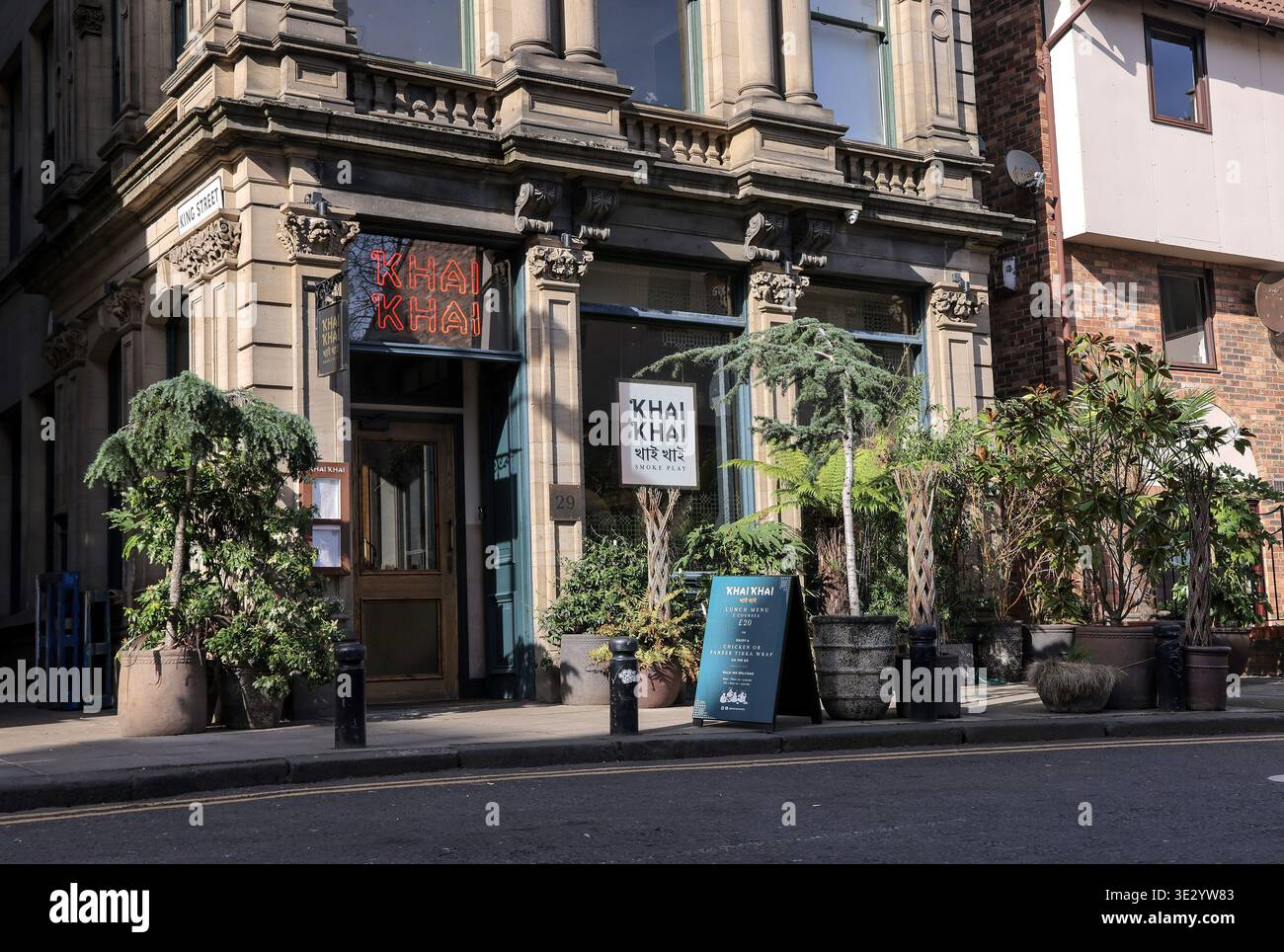 Il ristorante indiano Khai Khai si trova in Queen Street, Newcastle Quayside. Il ristorante presenta un'accogliente entrata con piante e cartelli che attirano i visitatori. L'area e' conosciuta per la sua atmosfera vivace ed e' un posto preferito per mangiare e socializzare. I visitatori possono ammirare i vari luoghi di interesse locali nelle vicinanze mentre esplorano questa vivace zona di Newcastle. Il ristorante offre cucina indiana tradizionale e un vivace ambiente da pranzo, rendendolo una scelta popolare sia per la gente del posto che per i turisti. Foto Stock