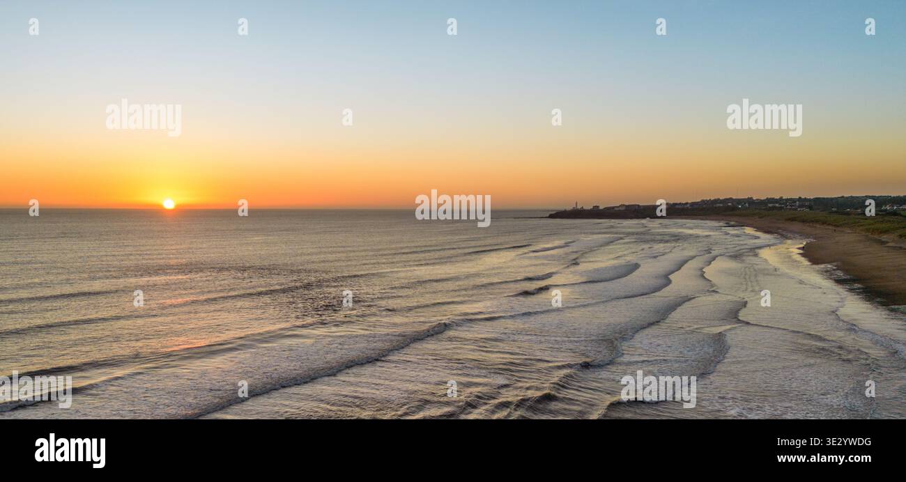 Una foto con un drone della spiaggia deserta di Seaton e delle dune di sabbia nel Northumberland, all'alba in una mattina fredda e limpida Foto Stock