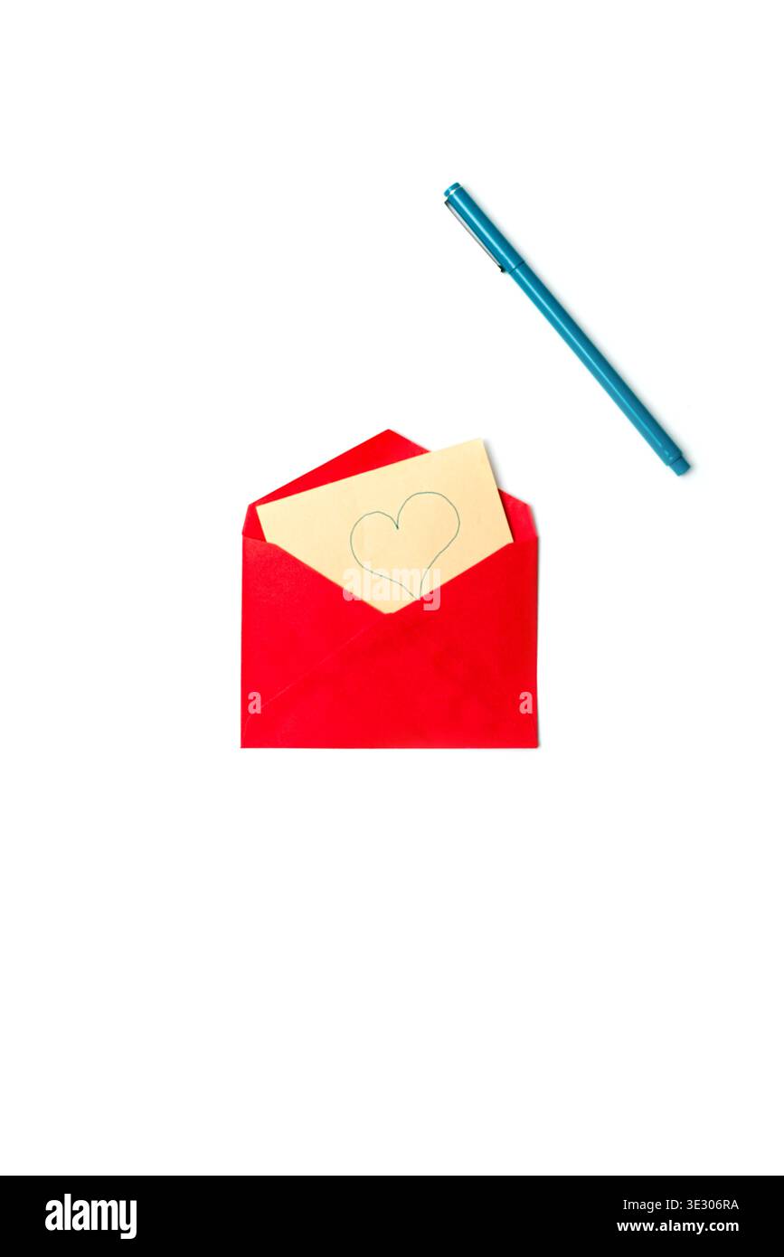 Una busta rossa con una Love card beige con un cuore disegnato a mano, posizionata su uno sfondo minimalista pulito con una penna. Foto Stock