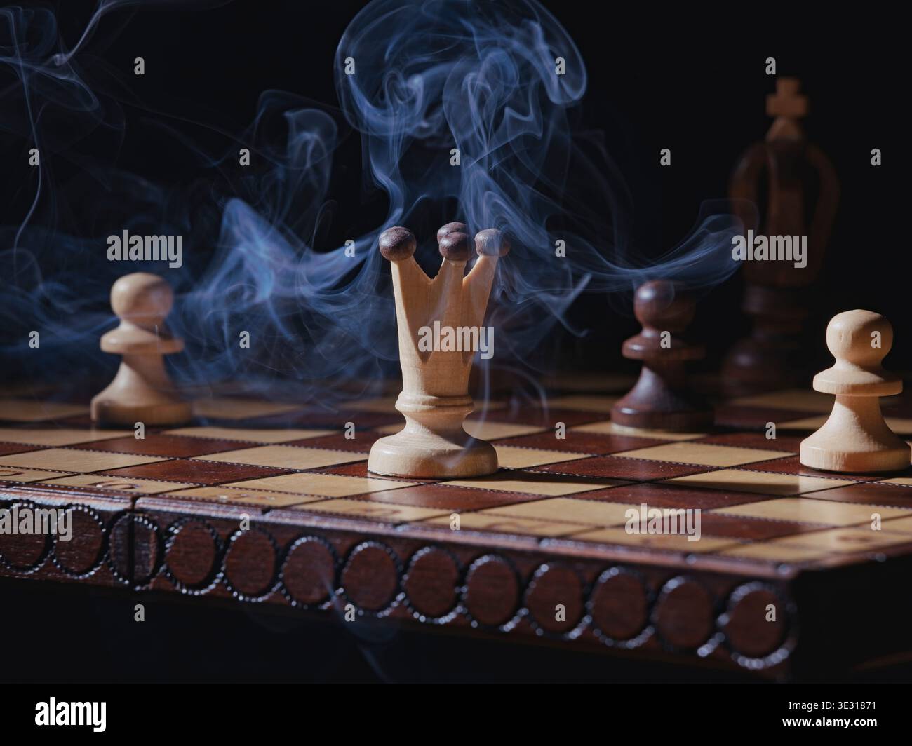 Un primo piano di una foto concettuale di fumo che si libra su una scacchiera con alcuni pezzi di scacchi. Foto Stock