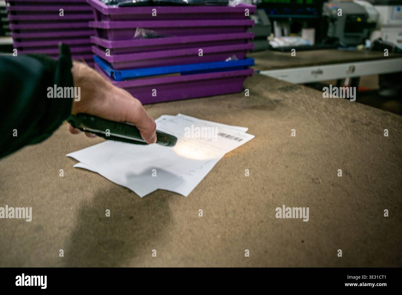 Operatività del magazzino utilizzando uno scanner portatile per leggere un codice a barre su documenti di prelievo o spedizione in un magazzino di e-commerce o in un centro di distribuzione Foto Stock