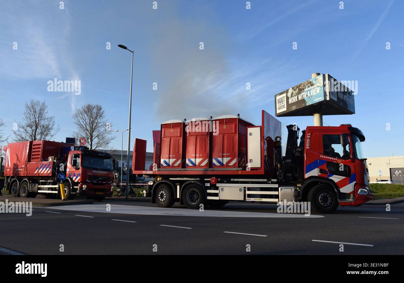 Amsterdam. 20 marzo 2026. I camion dei vigili del fuoco si dirigono verso il sito dei vigili del fuoco di Amsterdam, Paesi Bassi, il 20 marzo 2026. Un grande incendio scoppiato venerdì nella zona industriale di Westpoort, nella parte occidentale di Amsterdam, nei Paesi Bassi, è stato messo sotto controllo, senza alcuna notizia di vittime, ha detto i vigili del fuoco locali. Crediti: Shao Haijun/Xinhua/Alamy Live News Foto Stock