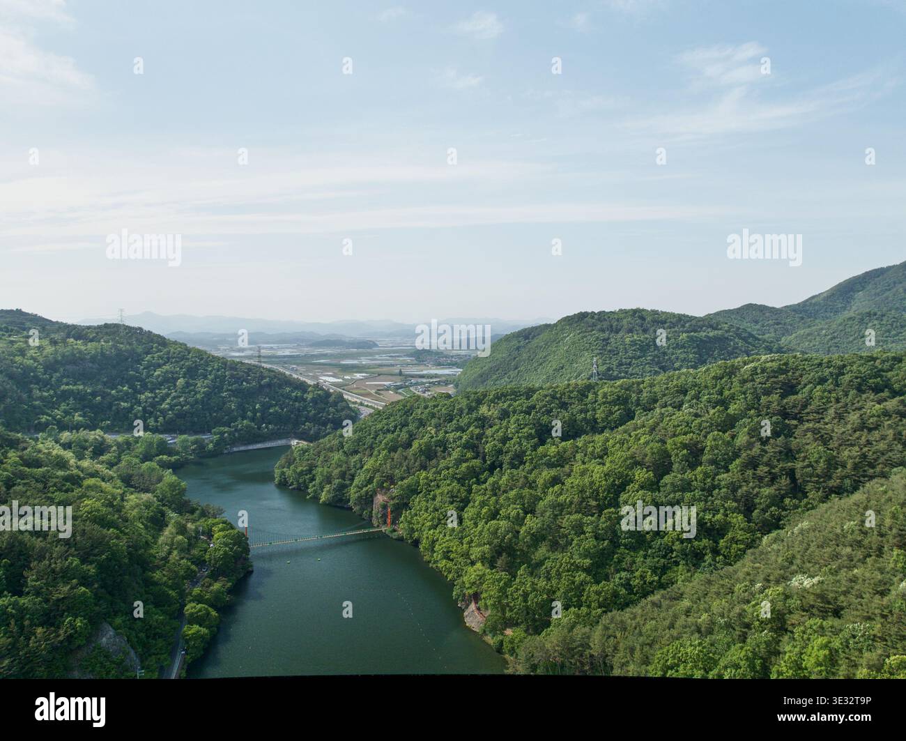 Vista aerea del Mujinjeong ad Haman, Corea del Sud. Il padiglione tradizionale si armonizza splendidamente con un tranquillo laghetto, alberi lussureggianti e il ponte di pietra. Foto Stock