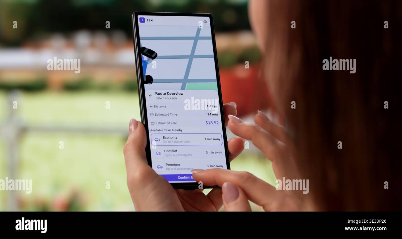 Donna che prenota un taxi tramite l'app mobile in ambiente urbano Foto Stock