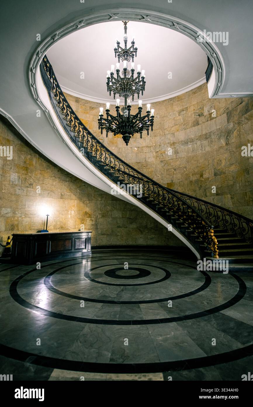 Elegante scalinata curva con lampadari e pavimento in marmo nell'edificio Ministério da Fazenda di Rio de Janeiro, Brasile Foto Stock