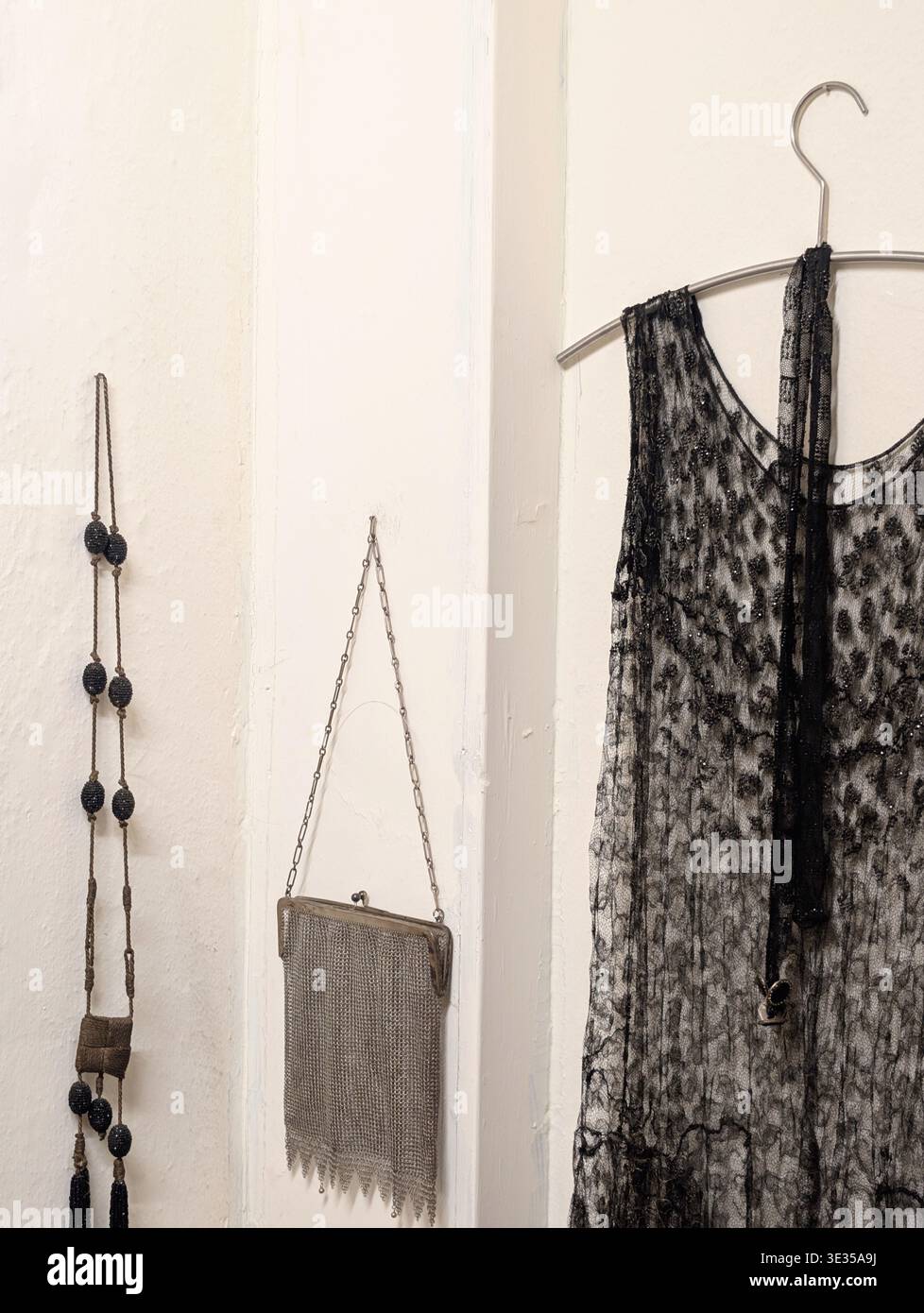 Abito da donna vintage con impiccagione e borsa e collana in un armadio. Foto Stock