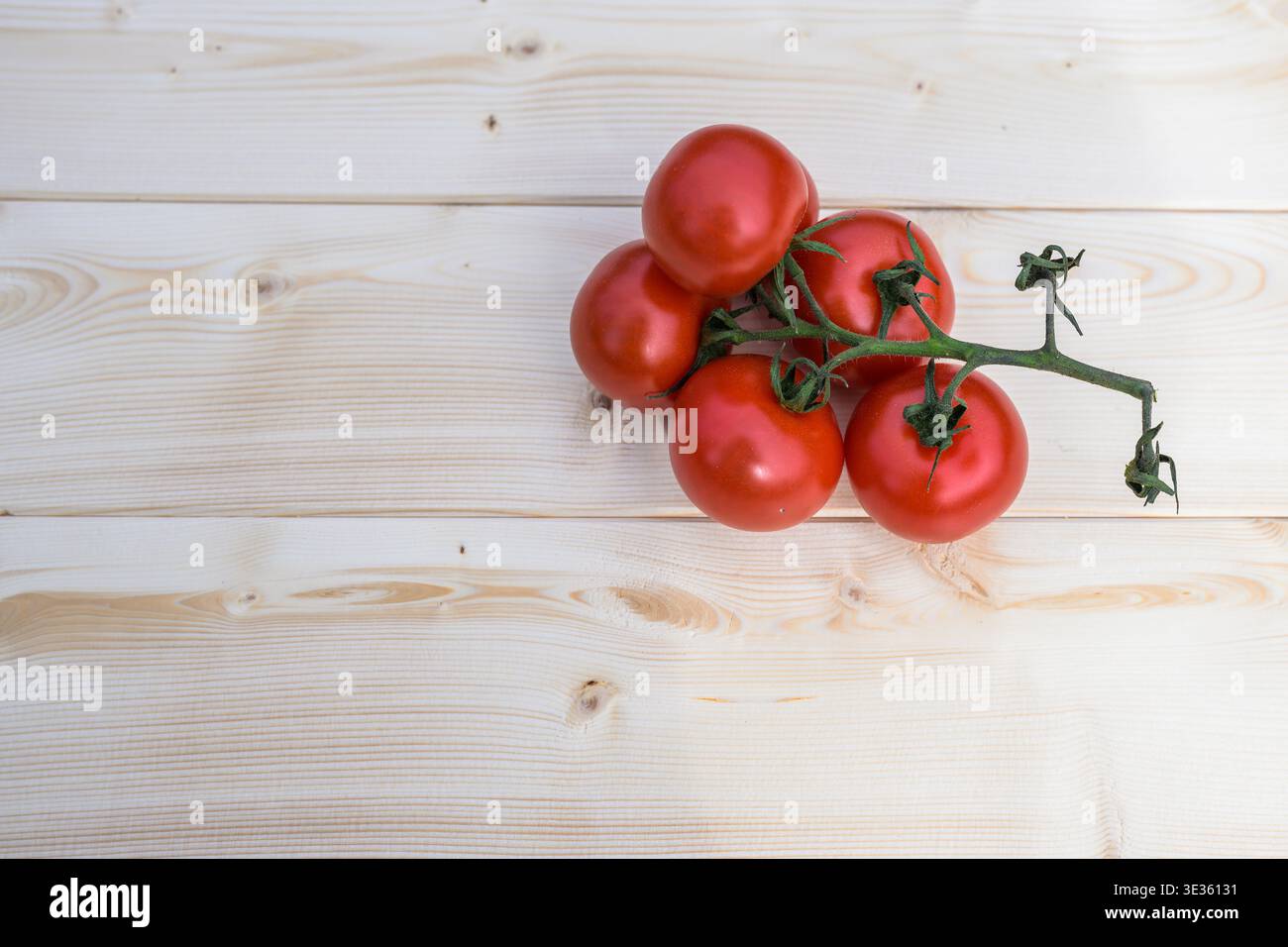 Pomodori maturi in legno esposti su un rustico tavolo in legno, che mette in risalto la freschezza, il colore rosso vivace e il fascino naturale da fattoria a tavola. Foto Stock