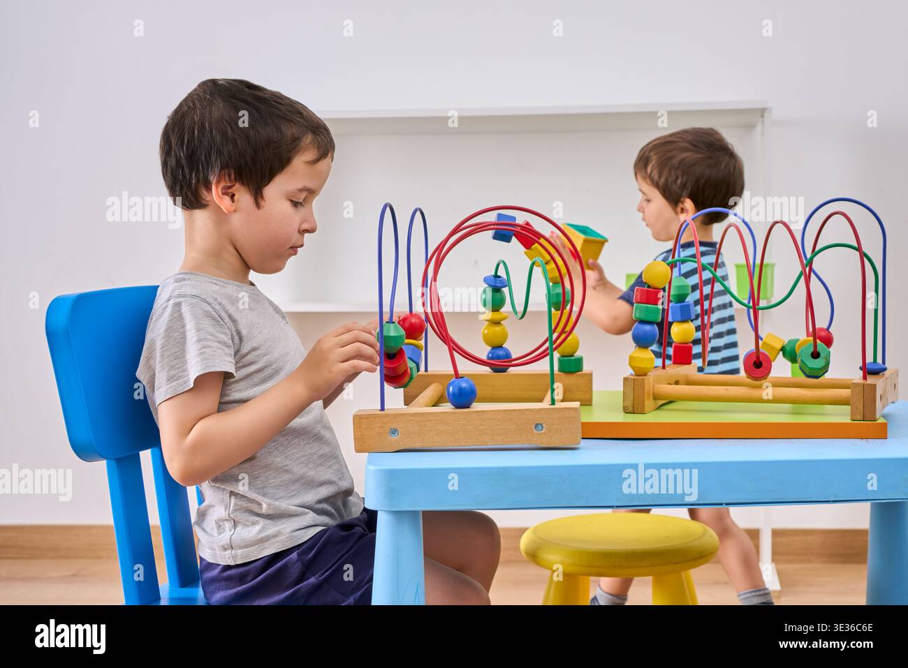Bambini, blocchi e edifici con giocattoli in ufficio per attività divertenti, valutazione o gioco sul pavimento. Bambini o studenti con forme per un apprendimento giocoso, belle m Foto Stock