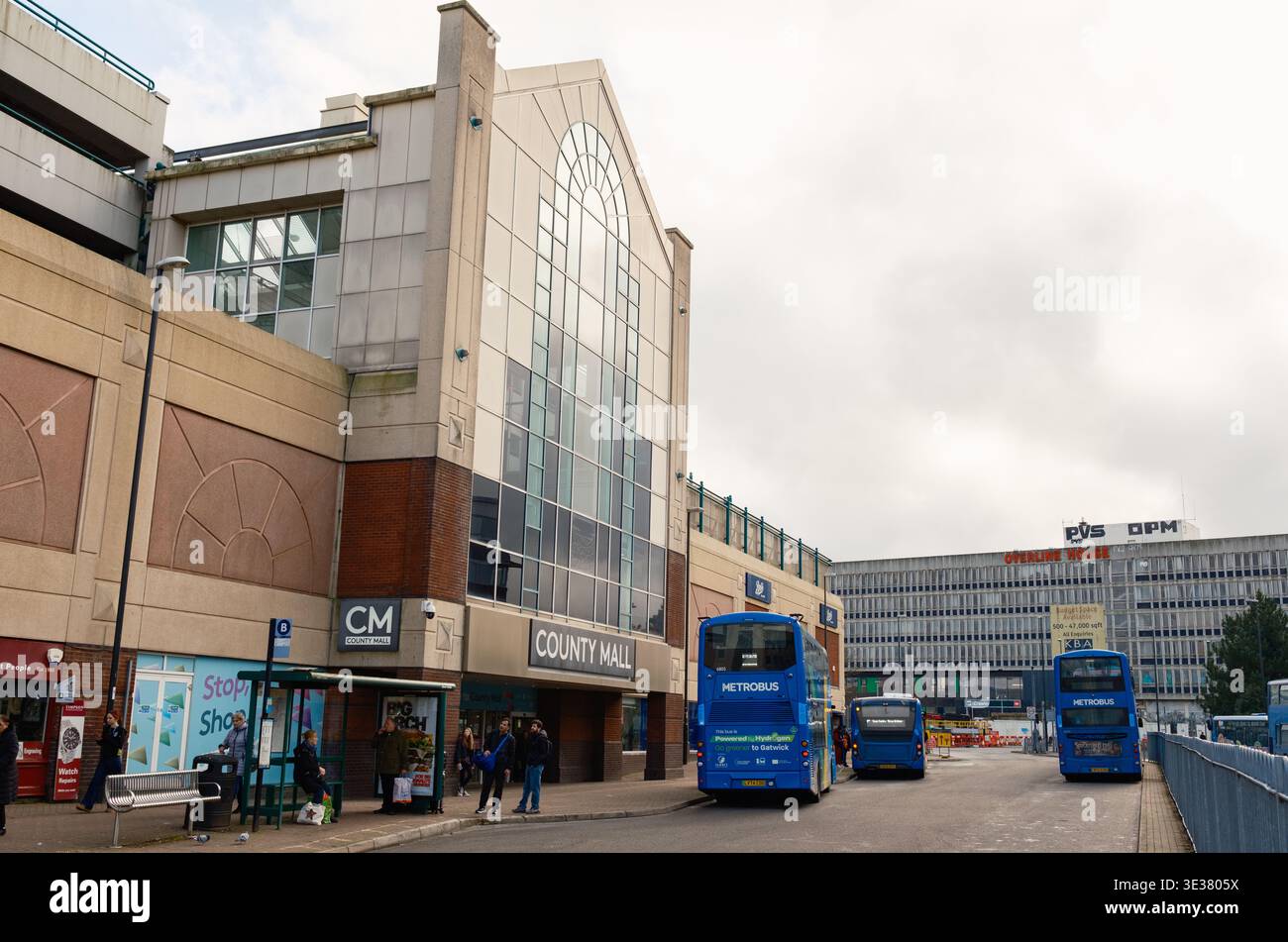 Stazione degli autobus di County Mall a Crawley, Inghilterra, con autobus e il centro commerciale con vista in vetro. Foto Stock