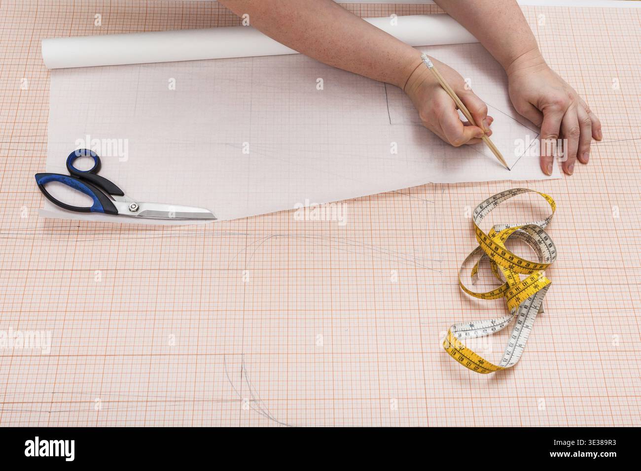 Tailor copia il modello di abbigliamento disegnato a mano su carta da ricalco Foto Stock