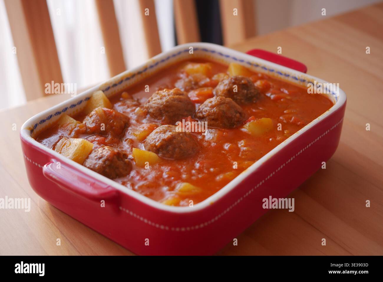 Polpette e verdure in salsa rossa su un tavolo da pranzo Foto Stock