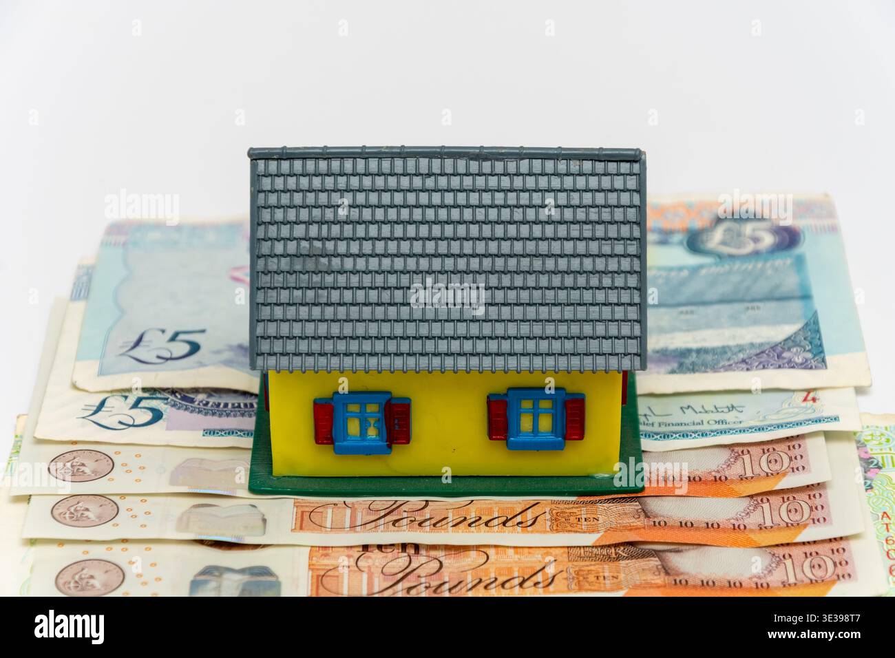 Mini casa in sterline britanniche che riflettono il mutuo e il mercato immobiliare inglese. Foto Stock