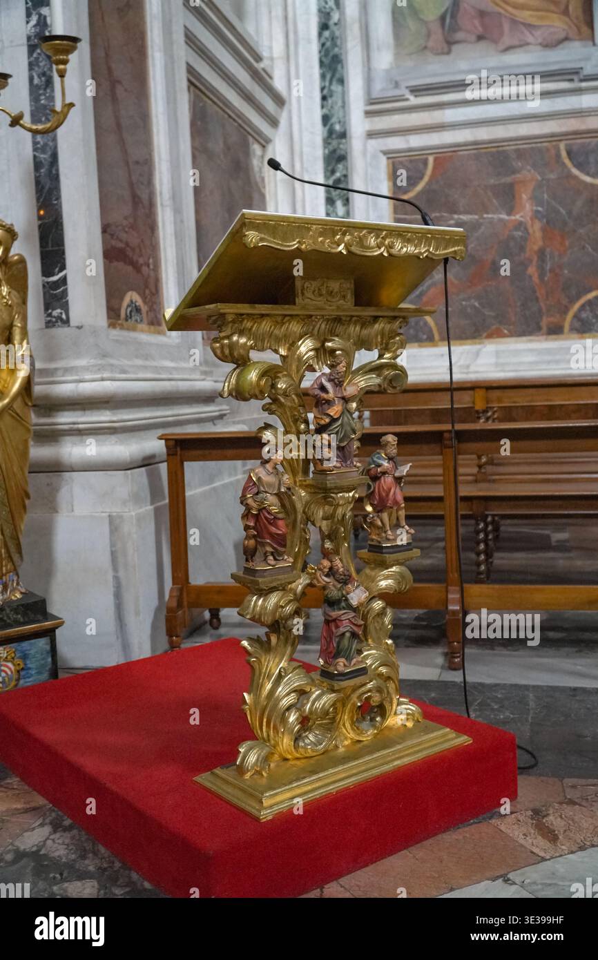 Basilica Papale di Roma, Italia. Elaborata scultura di leggio in stile barocco sulla piattaforma rossa all'interno di una grande basilica papale di Roma. Foto Stock