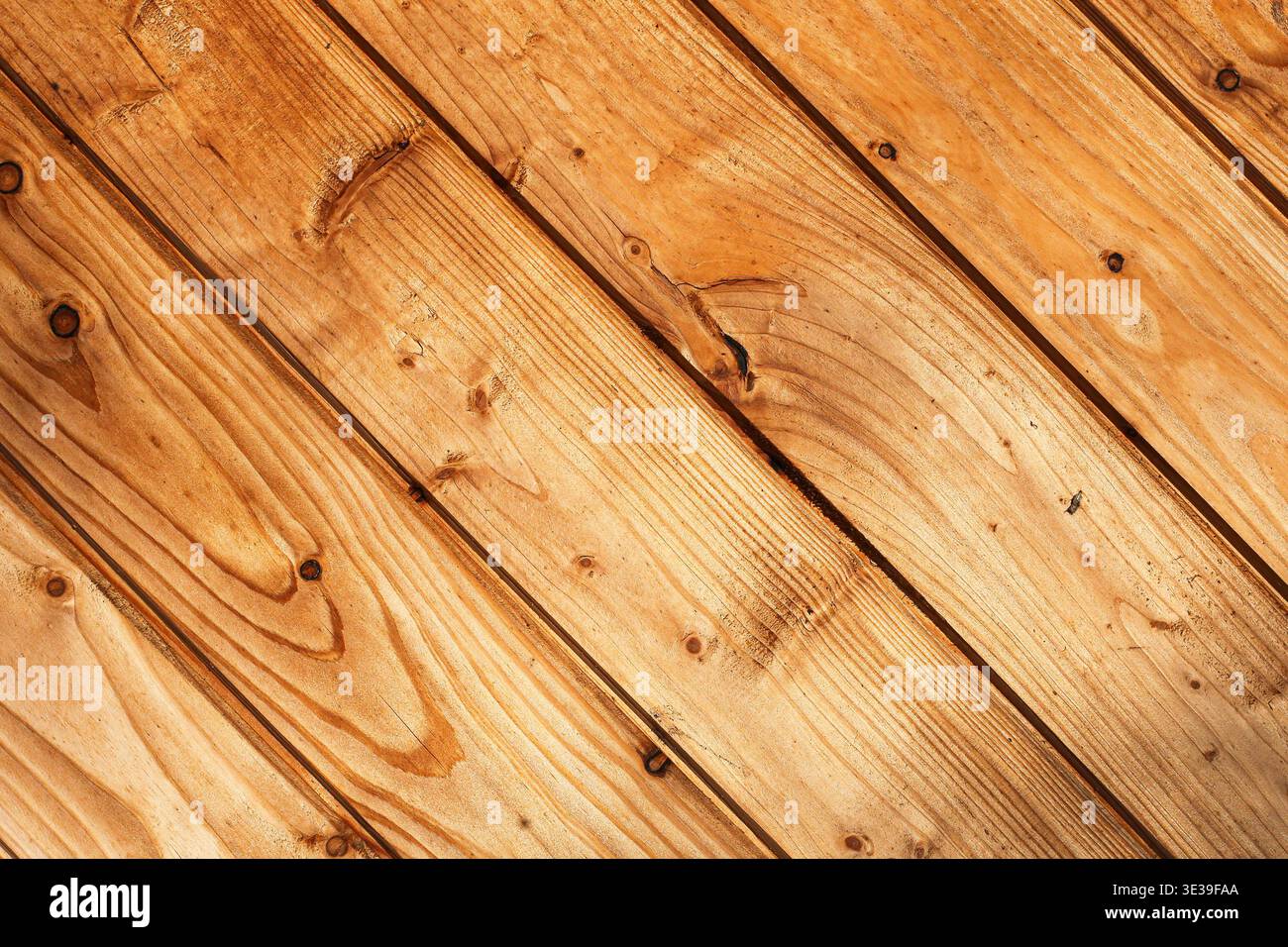 Tavole di legno sullo sfondo dai toni caldi. Struttura in legno naturale con grana e nodi visibili. Superficie rustica per il design o il concetto di interni Foto Stock