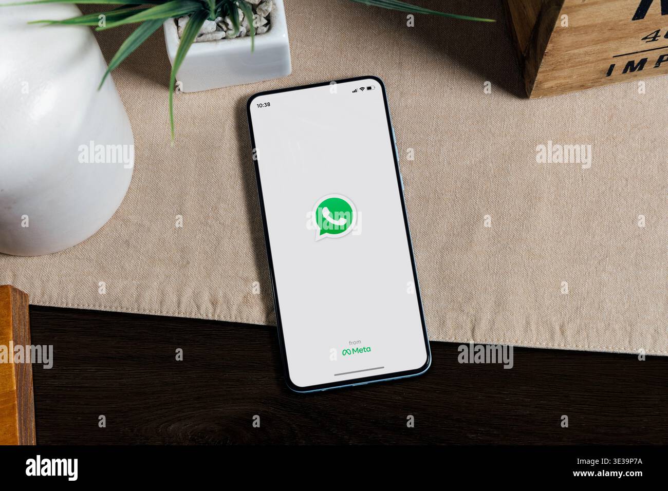 Smartphone che visualizza l'app WhatsApp sullo schermo sulla scrivania, messaggistica mobile e comunicazione digitale. Foto Stock