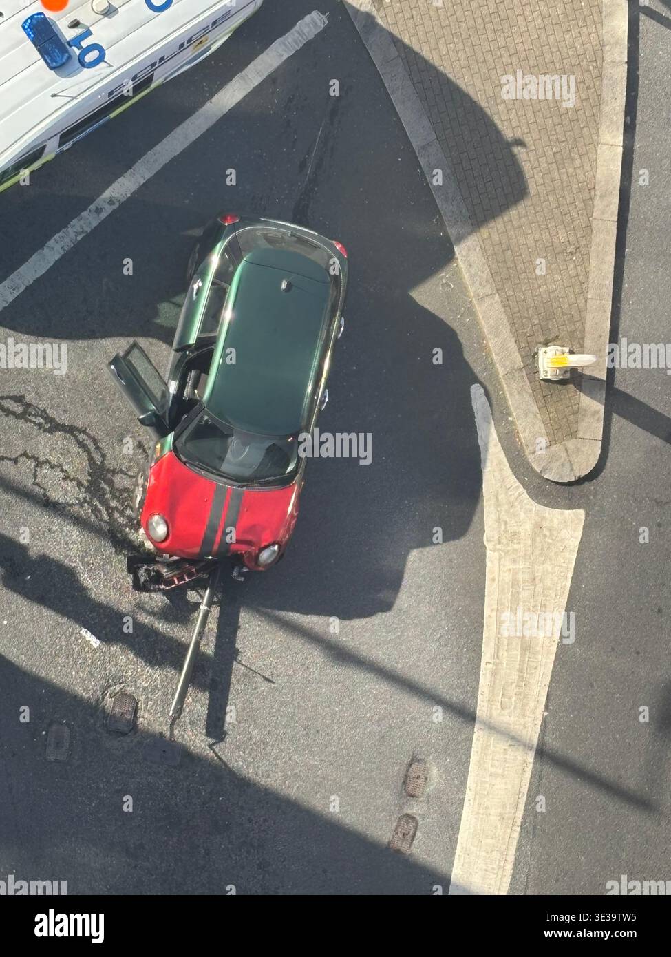 Vista dall'alto di un furgone della polizia che segue la scena di un incidente stradale che coinvolge una mini rossa e verde che ha avuto un impatto con il traffico. - Immagine stock catturata con smartphone