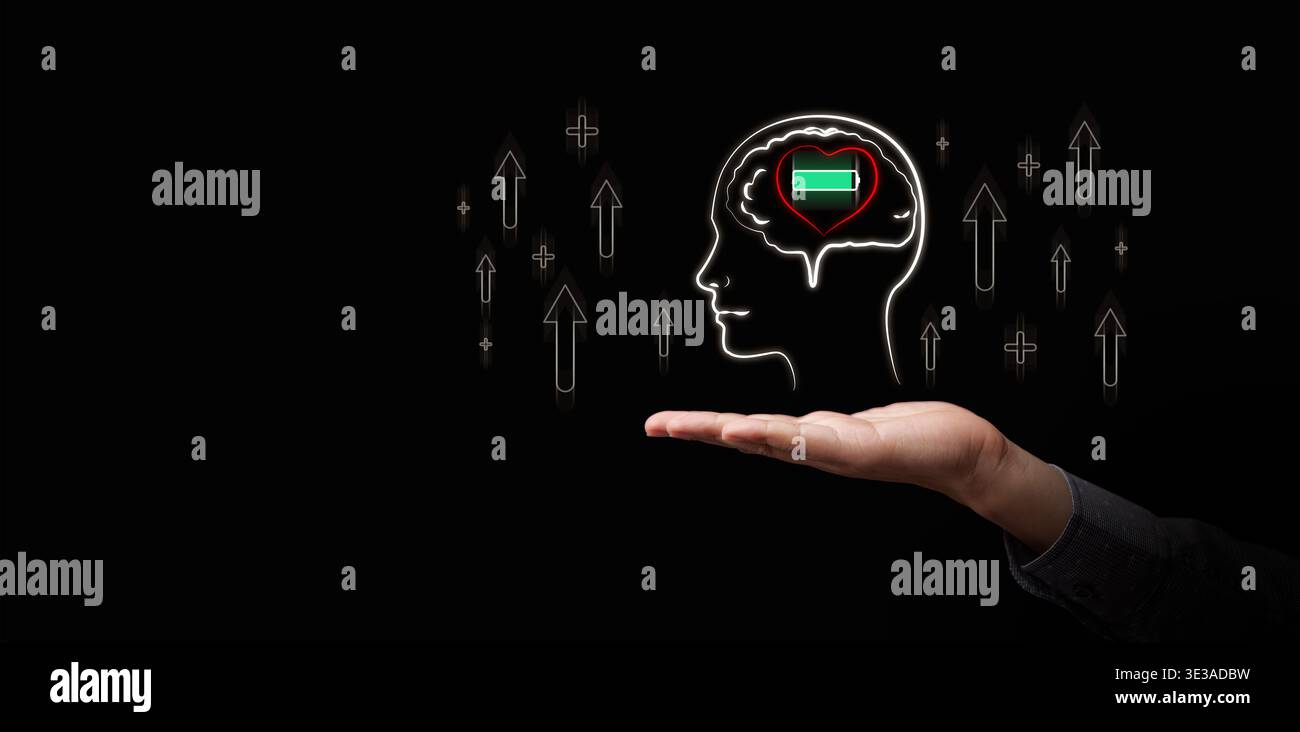Testa umana con cuore incandescente all'interno del cervello e icona della batteria piena di energia sopra la mano. Salute mentale, atteggiamento sano e mentalità, intelligenc emotivo Foto Stock