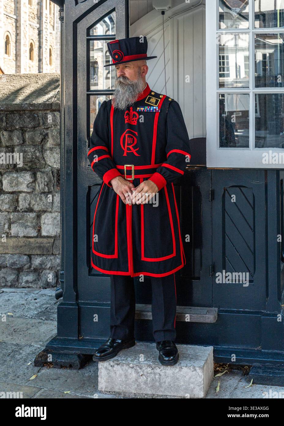 Uno Yeoman Warder in tradizionale uniforme blu e rossa alla Torre di Londra, Inghilterra Foto Stock
