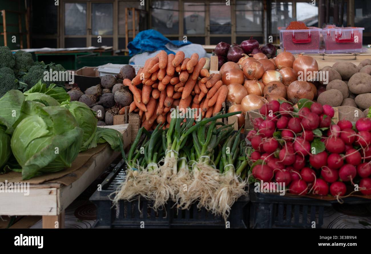 Una parte di un mercato con carote, cavolo, cipolla, patate, ravanelli, aglio e broccoli. Foto Stock