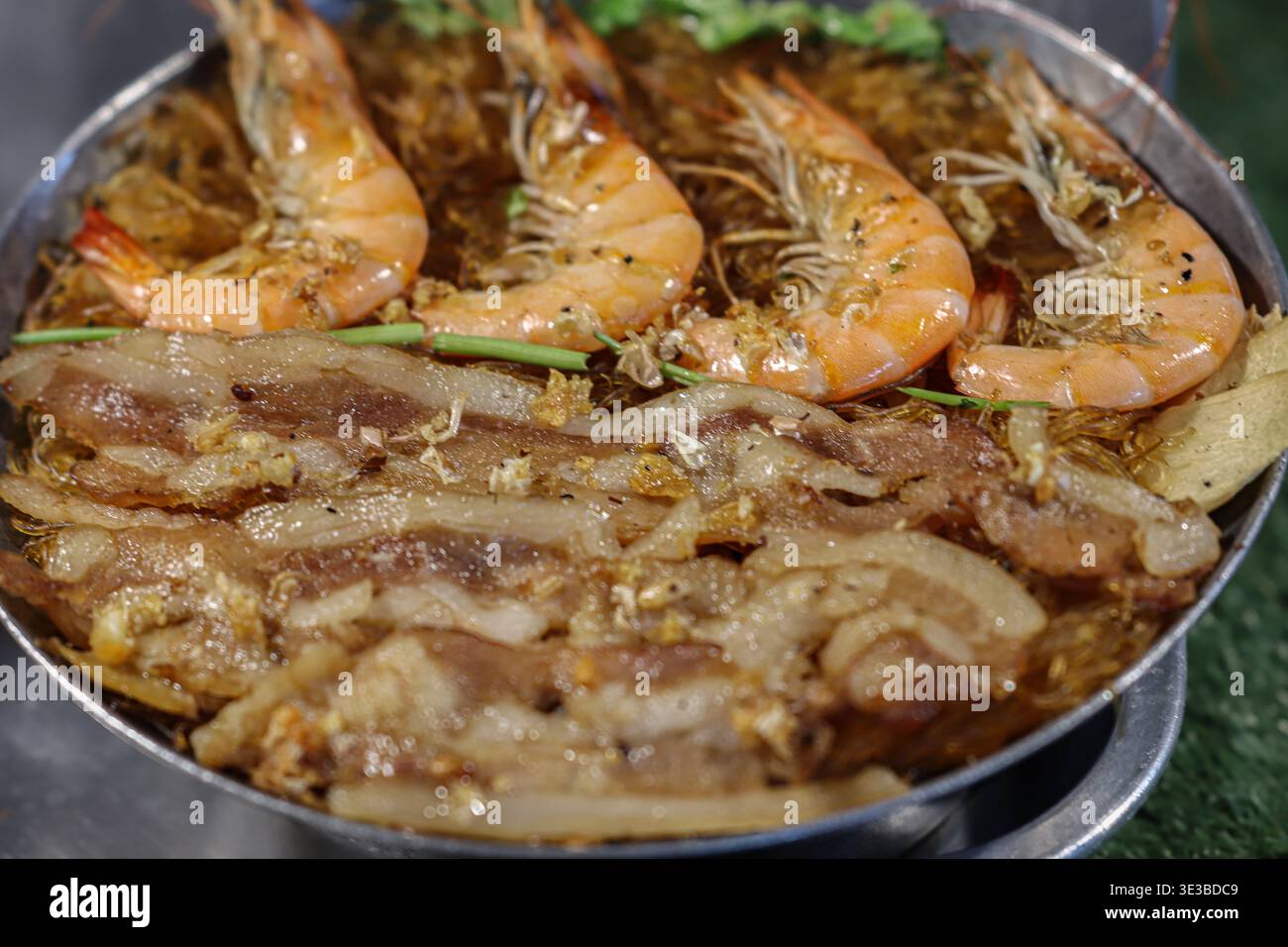 Gamberi tailandesi al forno con spaghetti di vetro e maiale in una padella calda, mostrando autentica cucina di strada e ricchi sapori asiatici. Foto Stock