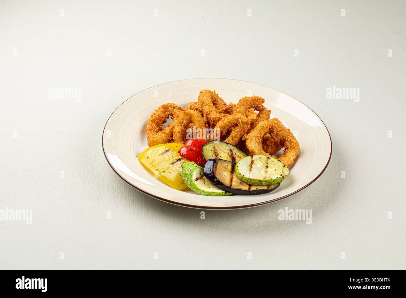 Anelli di cipolla fritti croccanti con verdure grigliate Foto Stock