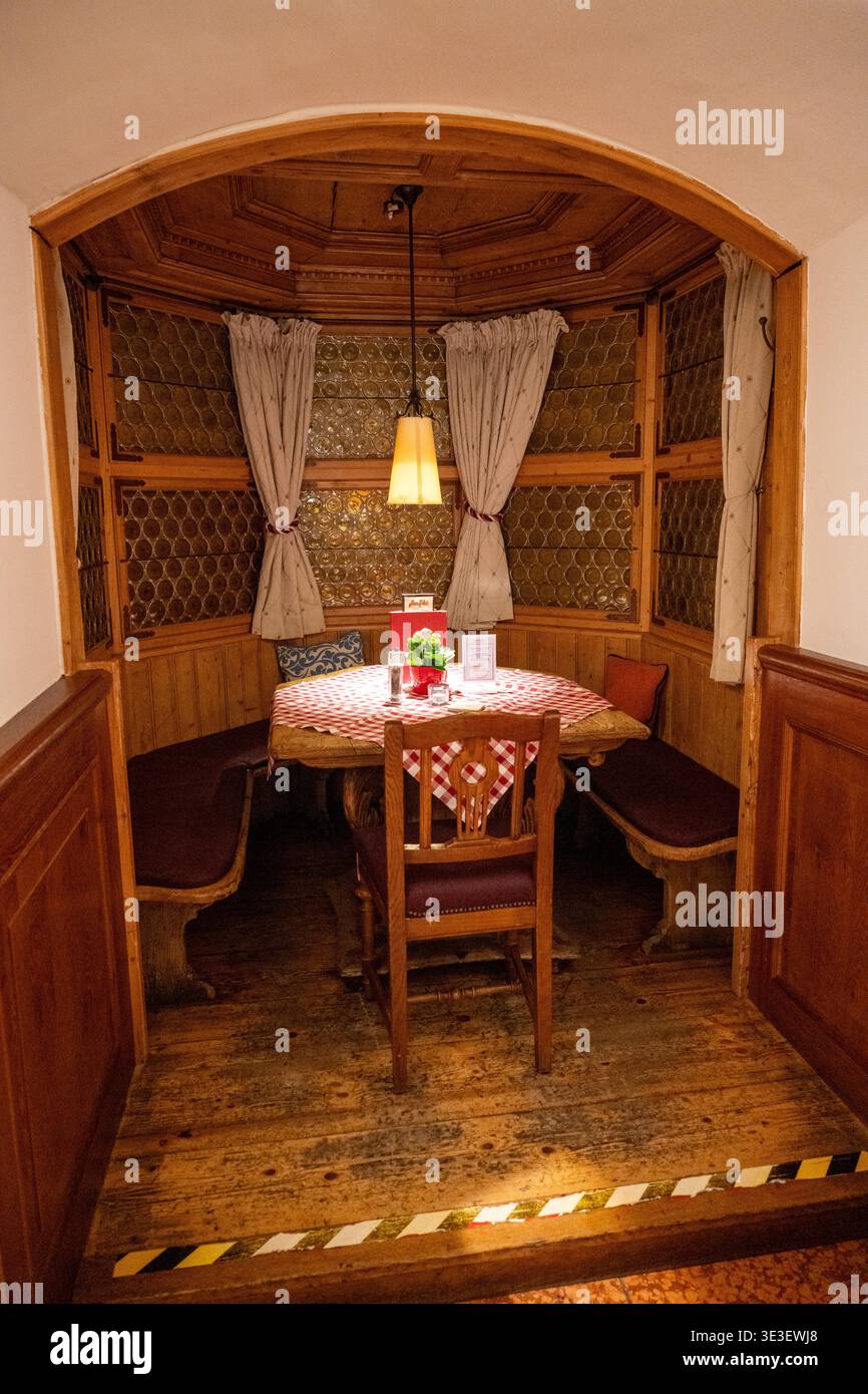 Monaco di Baviera, Germania - 29 marzo 24: Intimo stand in legno presso il Munich Ratskeller con pannelli intagliati, vetri a fantasia, tende e un piccolo set da tavolo Foto Stock