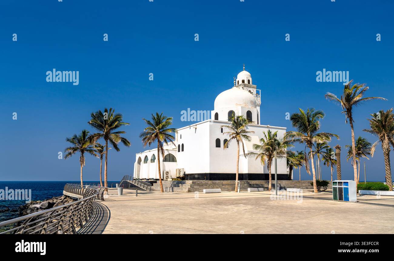 La moschea dell'isola bianca si erge in modo prominente lungo la costa del Mar Rosso sulla Corniche di Jeddah in Arabia Saudita, incorniciata da palme tropicali sotto un cielo azzurro. Foto Stock