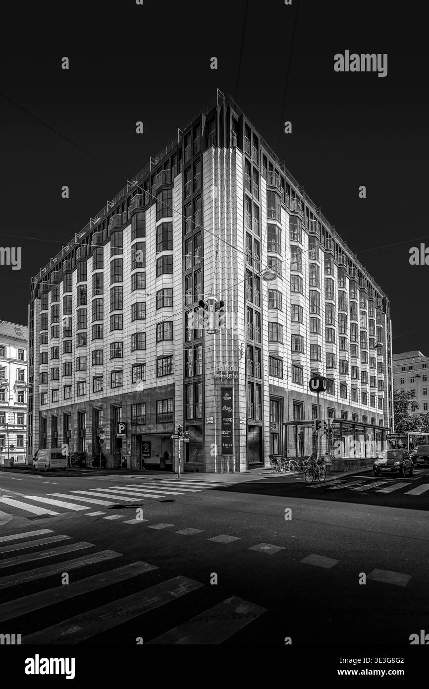 Suggestiva immagine in bianco e nero di un edificio urbano contemporaneo all'incrocio di una strada a Vienna, capitale dell'Austria. Foto Stock
