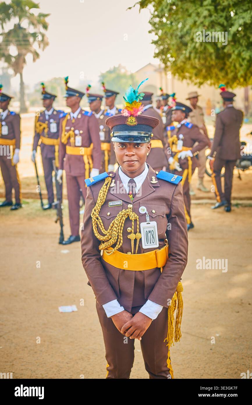 Kano, Nigeria - 17 ottobre 2021: Veduta di ufficiali in uniforme in formazione, il loro abbigliamento marrone e oro contrastante con il terreno polveroso e t Foto Stock