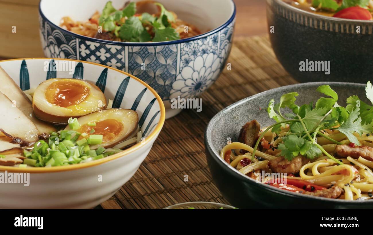 Ciotole assortite di noodle di ramen e friggere in padella con uova sode soffici Foto Stock