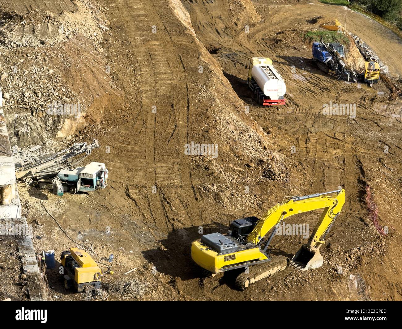 Vista dei veicoli da costruzione che scavano sentieri nella terra, un netto contrasto con il paesaggio naturale, uno scenario di industria e progresso, İstanbul, Foto Stock