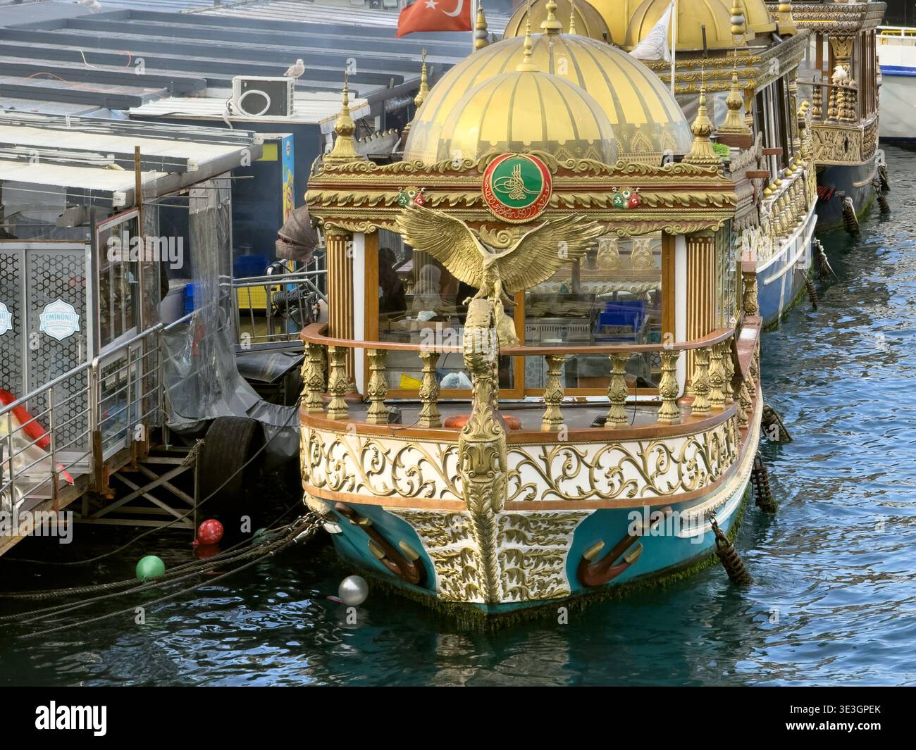 Vista delle barche ornate che si snodano dolcemente, le loro cupole dorate brillano, riflettendo sull'acqua, Istanbul, İstanbul, Türkiye. Foto Stock