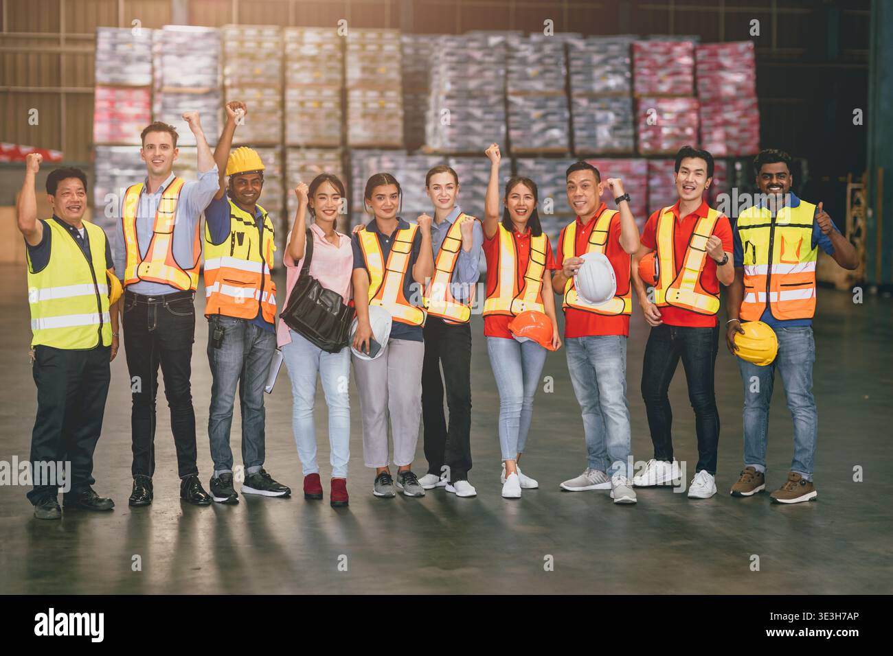un gruppo di addetti ai magazzini di fabbrica del settore lavora in gruppo con un sorriso felice. saluto riunione successo lavoratore mix razza e sesso. Foto Stock