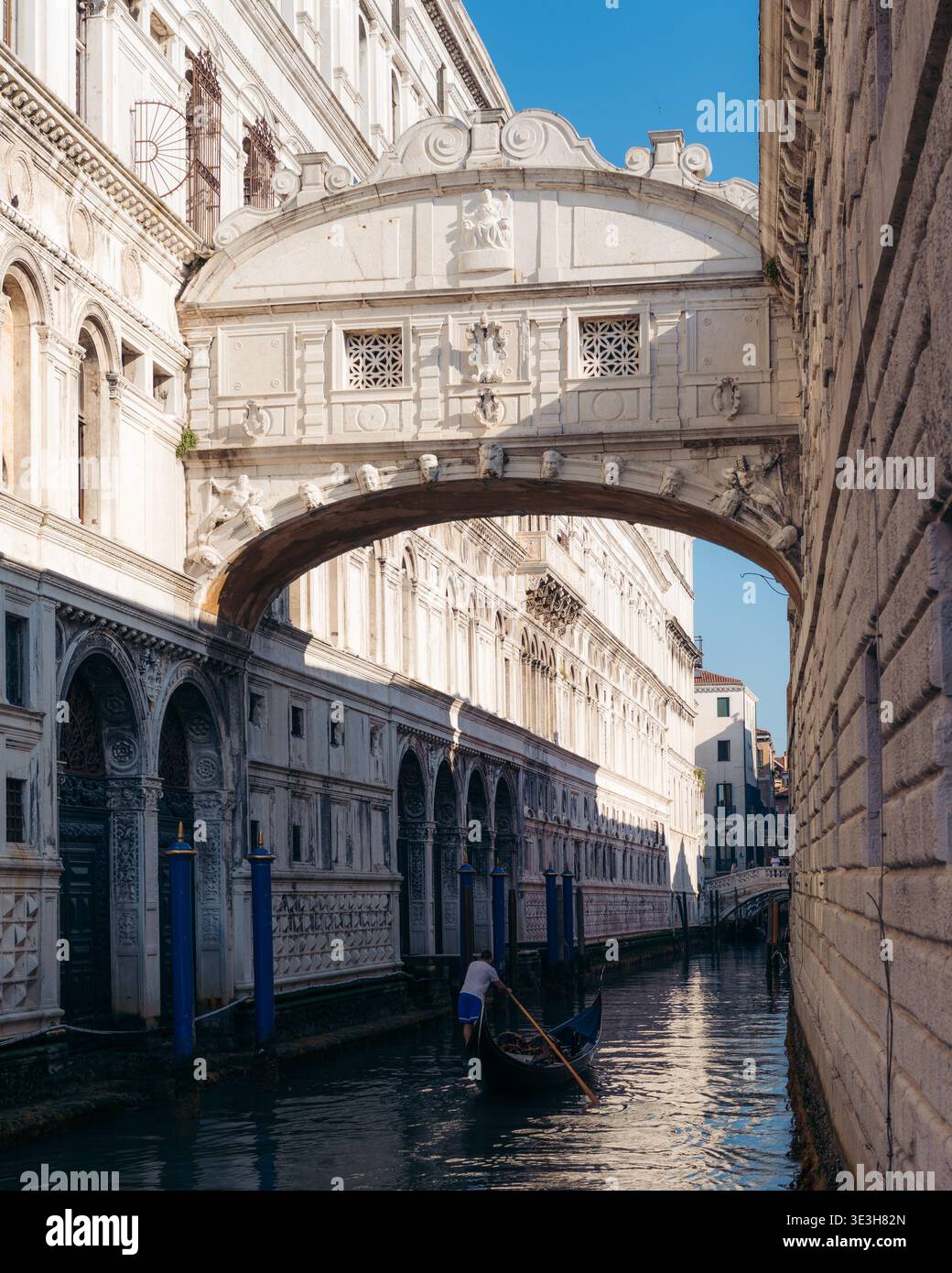 Veduta del Ponte dei Sospiri, un ponte chiuso di pietra calcarea bianca con finestre, archi sul canale con una gondola che passa sotto, Venezia, Veneto, Ital Foto Stock
