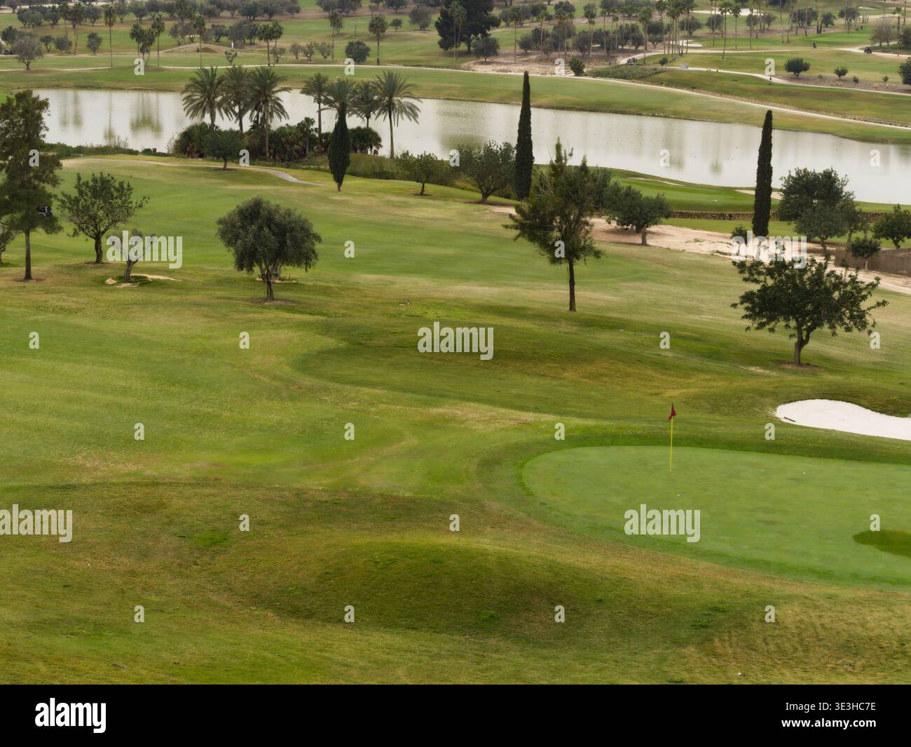 Grande stagno che confina con un campo da golf, fairway e green Foto Stock