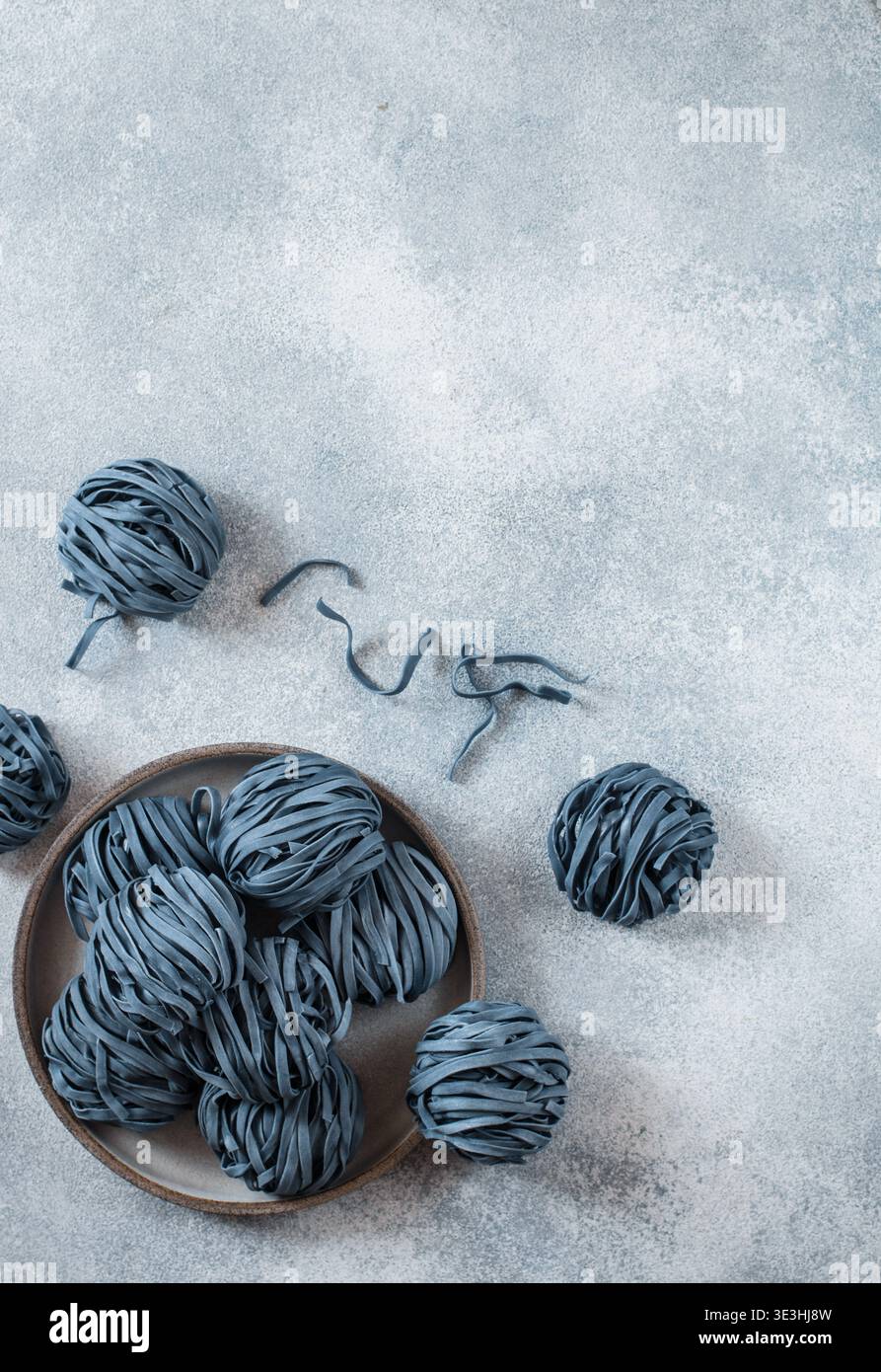 Spaghetti crudi di grano biologico con fiori di anchana. Il concetto di uno stile di vita sano e sportivo. fiori di pisello a farfalla. Cucina tailandese. Selettivo per Foto Stock