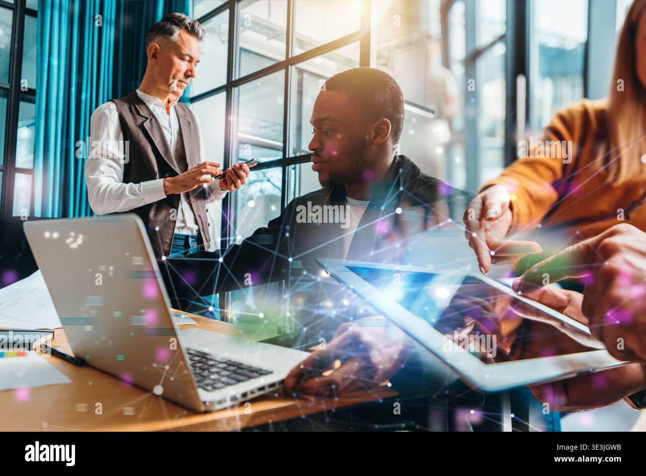 Gruppo di persone che lavorano insieme in un ufficio moderno durante il giorno su vari dispositivi digitali Foto Stock