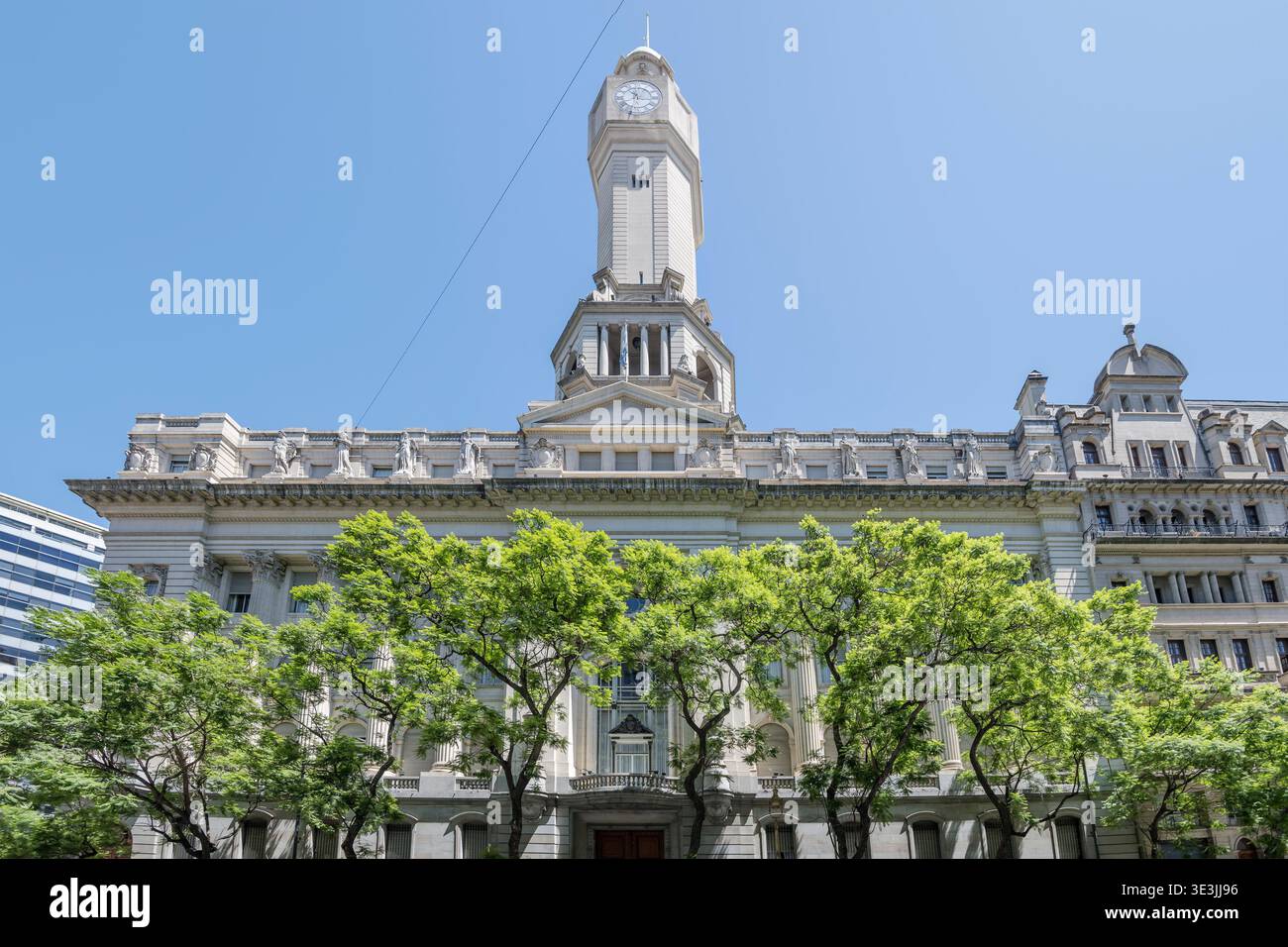 Paesaggio urbano con edifici ministeriali storici dietro gli alberi di avenida de Mayo, capitale dell'Argentina, girato alla luce dell'estate a Buenos Aires, Foto Stock