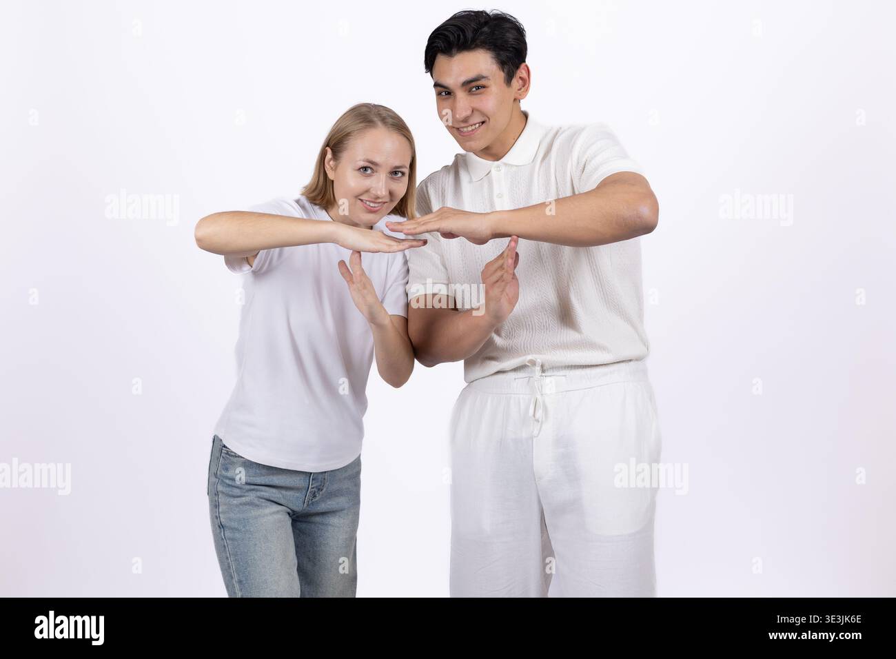 Giovane uomo e donna che mostrano un gesto cardiaco con le mani Foto Stock