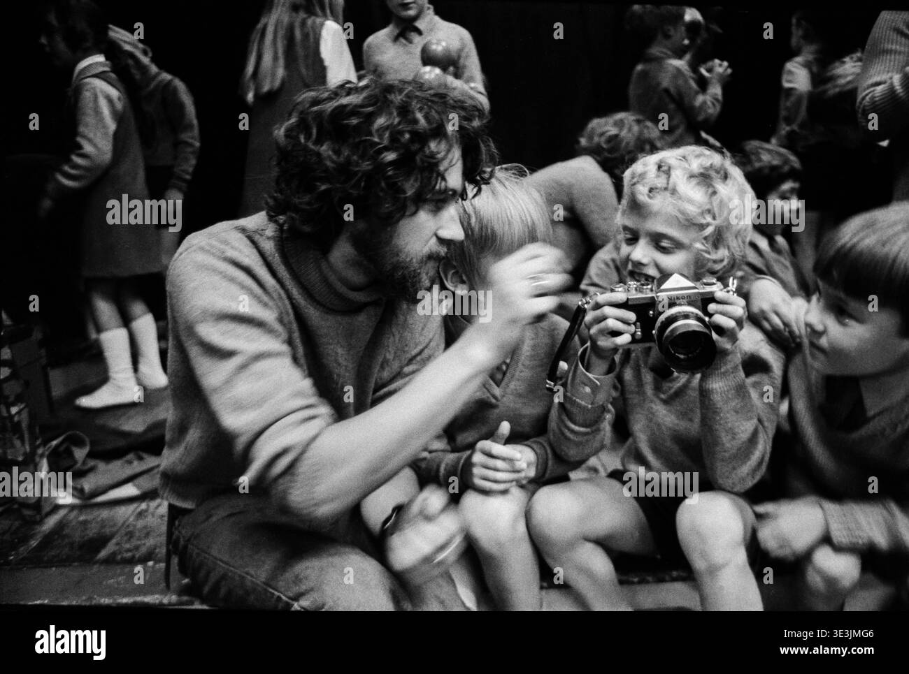 Un membro del gruppo di arte comunitaria Action Space Crew lascia che un ragazzo guardi la sua macchina fotografica durante un evento teatrale inlflatable in una scuola di Shrewsbury, 1973 Foto Stock