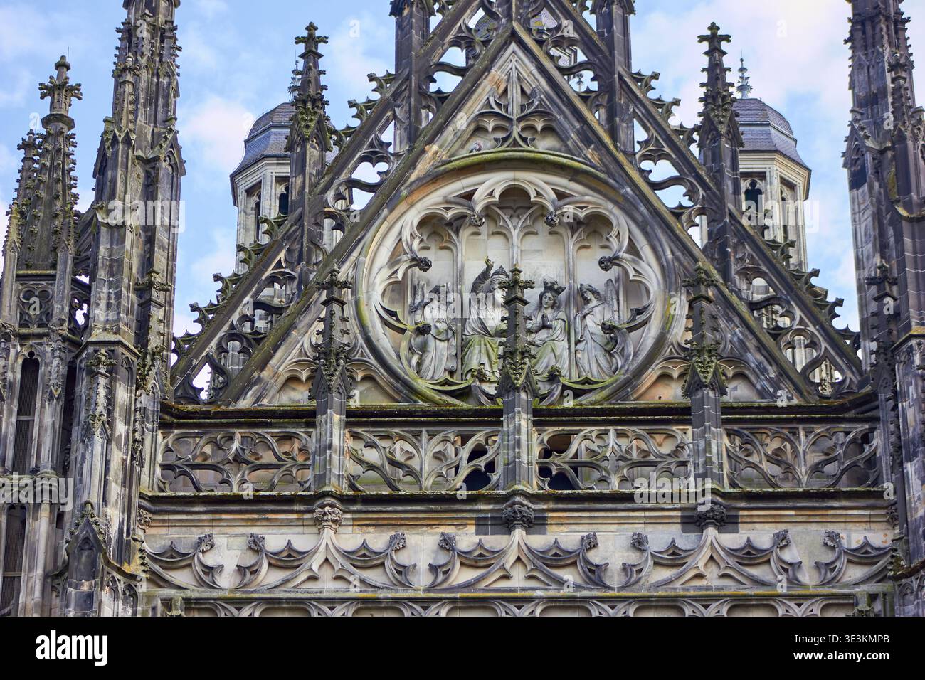 Vista ravvicinata della facciata gotica della cattedrale con elaborati tratti in pietra e dettagli scultorei. Il timpano triangolare centrale è caratterizzato da una struttura complessa Foto Stock