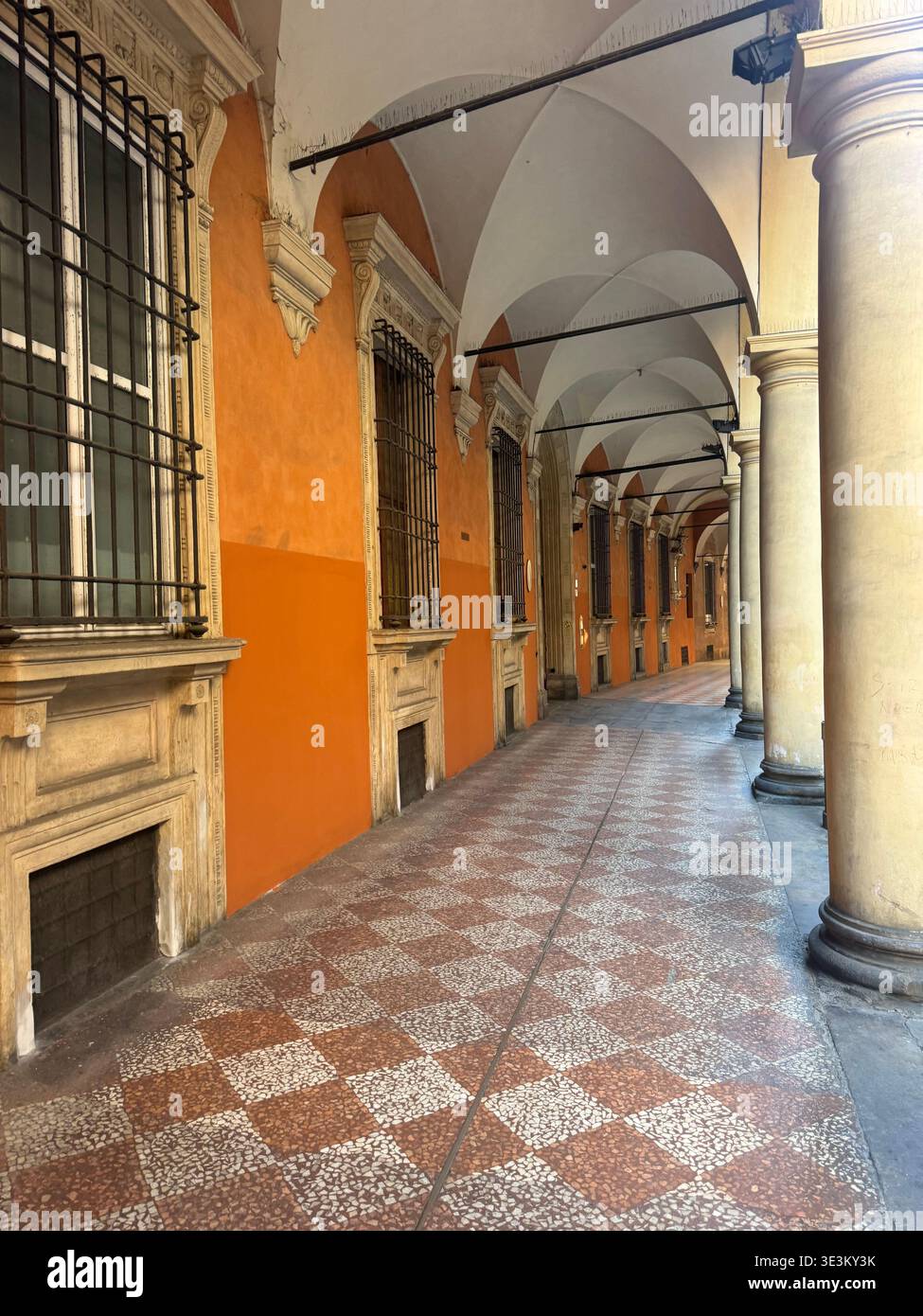 Portico storico di Bologna con archi, colonne e pareti arancioni, architettura classica italiana in Emilia-Romagna, Italia. - Immagine stock catturata con smartphone