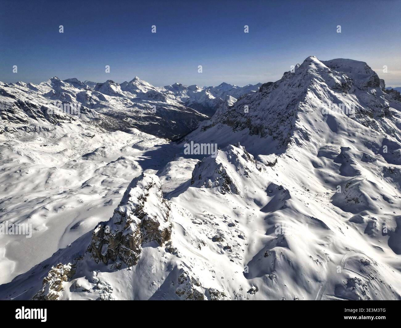 Vista aerea delle montagne innevate con ombre profonde sotto un cielo azzurro, Breuil-Cervinia, Valle d'Aosta, Italia. Foto Stock
