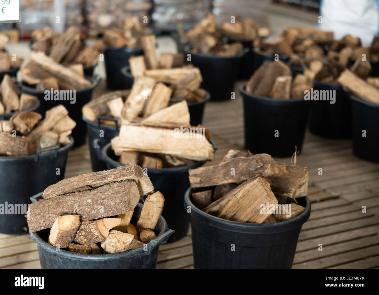 Legna da ardere impilata in secchi di plastica nel magazzino Foto Stock