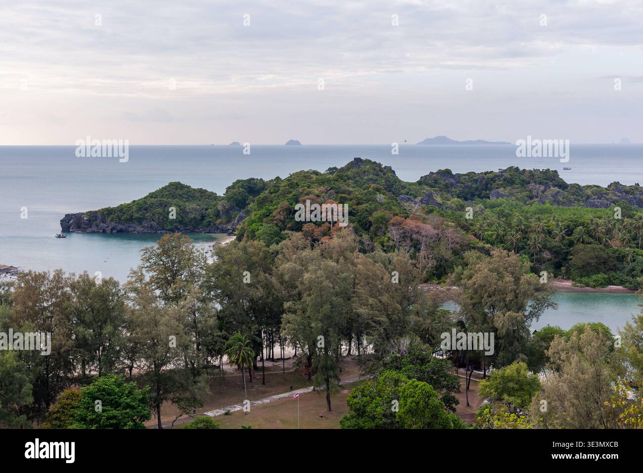 Isola di Koh Tarutao con vegetazione lussureggiante e acque cristalline. La fitta foresta incontra spiagge sabbiose e un mare calmo. Foto Stock