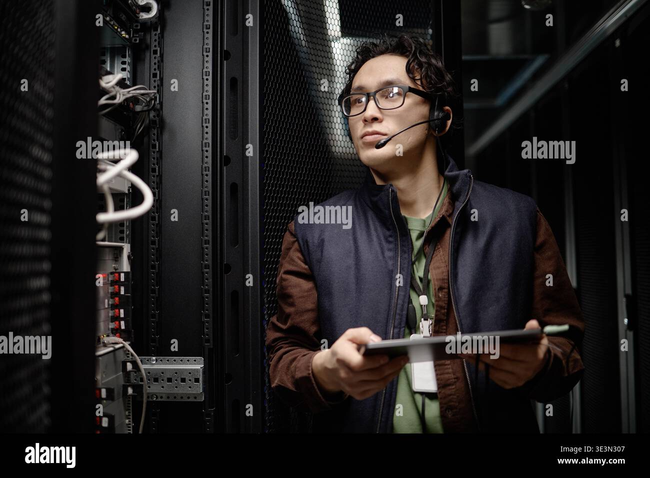 Apparecchiature per sala server di monitoraggio uomo asiatico con tablet digitale Foto Stock